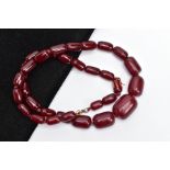 A CHERRY AMBER BAKELITE BEAD NECKLACE, graduated barrel shape beads, largest measuring 30.5mm x 24.