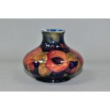 A MOORCROFT POTTERY SQUAT BALUSTER VASE IN THE POMEGRANATE PATTERN ON A MOTTLED BLUE GROUND, painted