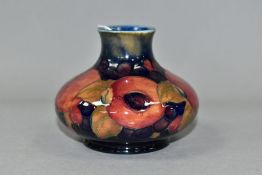 A MOORCROFT POTTERY SQUAT BALUSTER VASE IN THE POMEGRANATE PATTERN ON A MOTTLED BLUE GROUND, painted