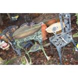 A CAST IRON PUB TABLE with a distressed wooden top 63cm in diameter and two modern garden chairs (