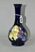 A MOORCROFT POTTERY BULBOUS SHAPED VASE DECORATED IN THE CLEMATIS PATTERN, on a dark blue ground,