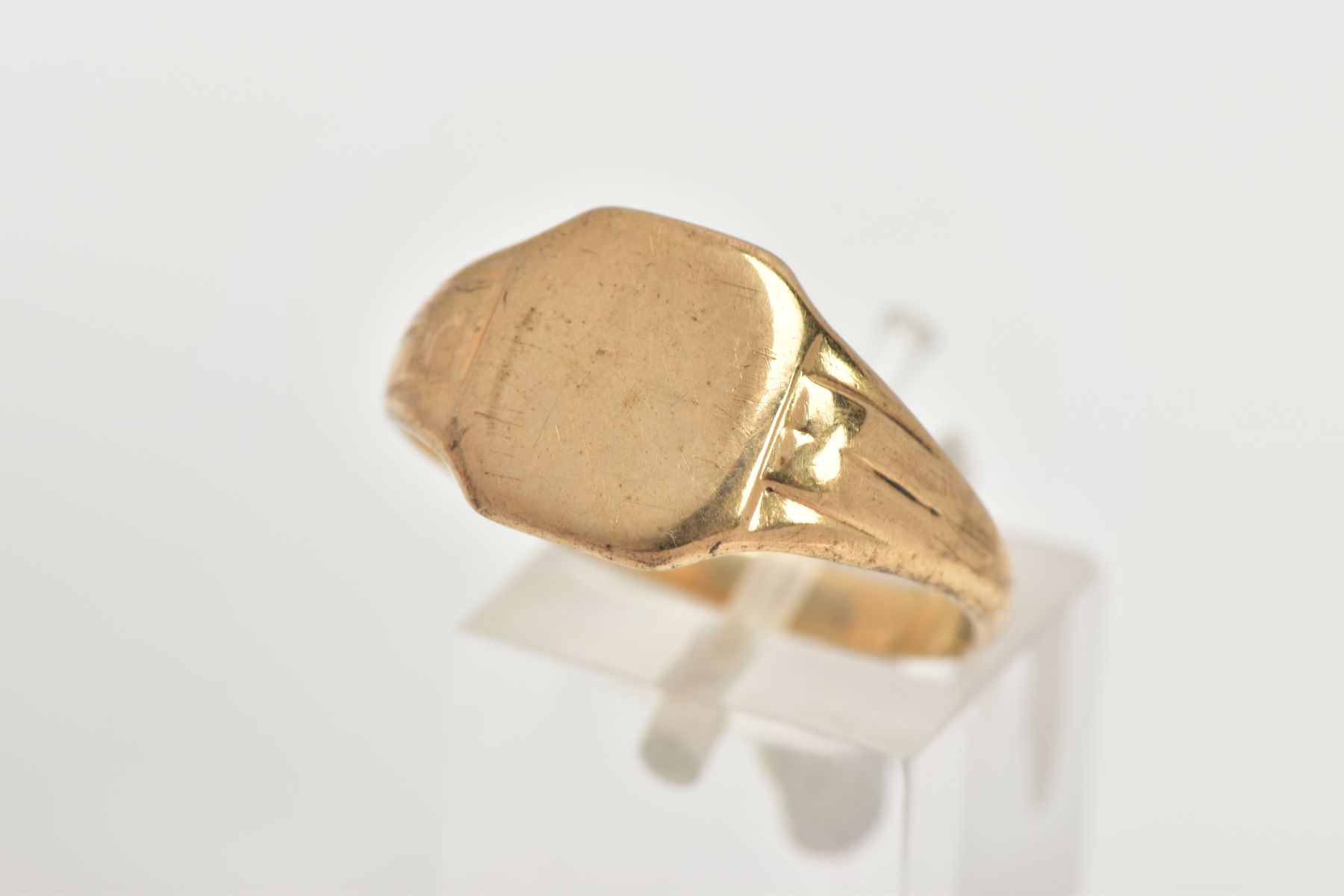 A 9CT GOLD SIGNET RING, of a plain square form, tapered shoulders, approximate face dimensions