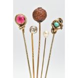 FIVE EARLY 20TH CENTURY STICK PINS, to include a circular nut pin, a red paste set pin, a colourless