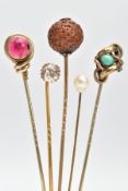 FIVE EARLY 20TH CENTURY STICK PINS, to include a circular nut pin, a red paste set pin, a colourless