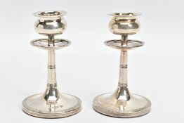 A PAIR OF SILVER EDWARDIAN DWARF CANDLESTICKS, each weighted candlestick designed with a tapered