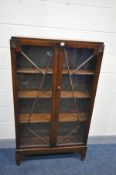 AN EARLY 20TH CENTURY OAK BOOKCASE with two glazed doors on turned feet, width 82cm x depth 27cm x