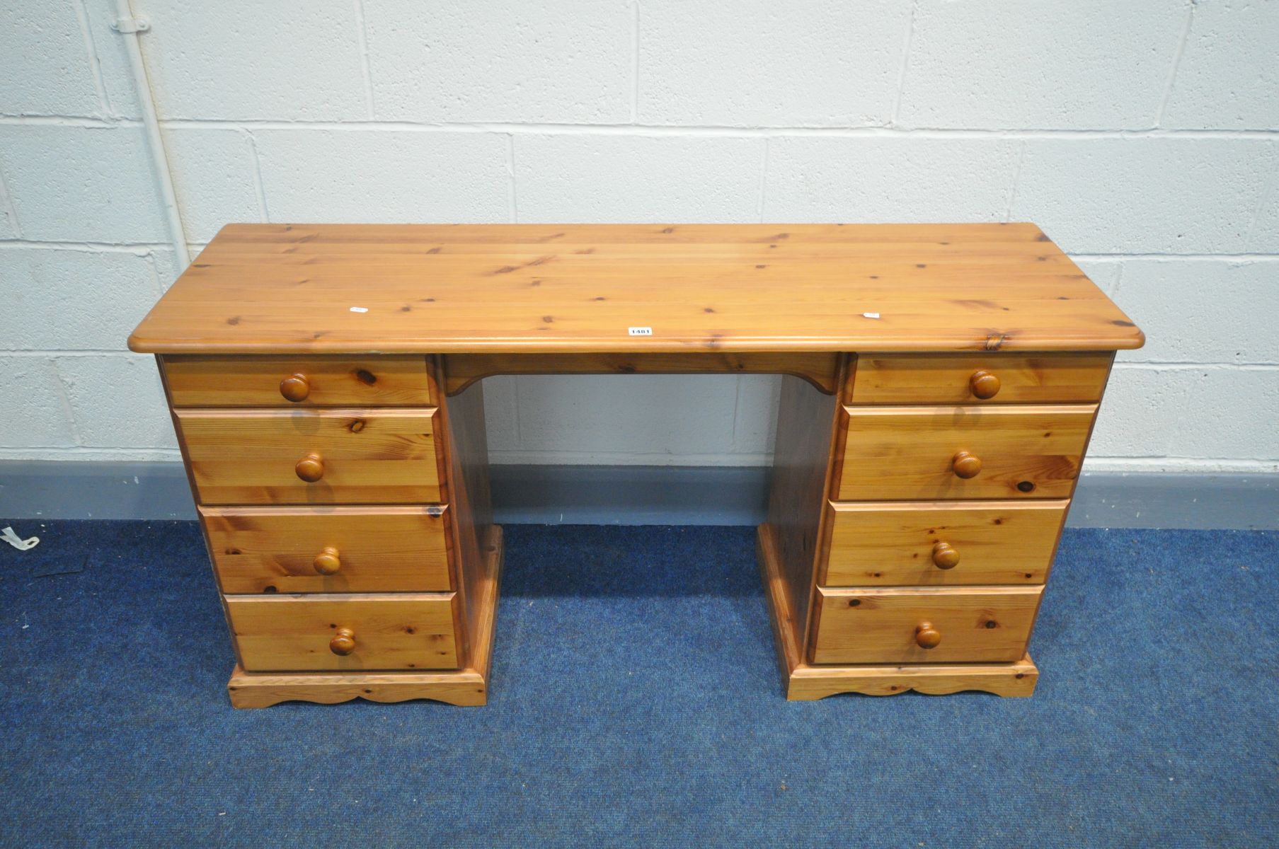 A MODERN PINE KNEE HOLE DESK/ DRESSING TABLE with two banks of four drawers, width 140cm x depth