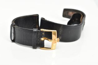 AN ORIGINAL BLACK 'ROLEX' WATCH STRAP, fitted with a yellow metal 'Rolex' motif ardillon buckle,