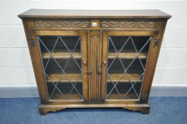 AN OAK LEAD GLAZED TWO DOOR BOOKCASE, width 110cm x depth 27cm x height 100cm