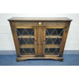 AN OAK LEAD GLAZED TWO DOOR BOOKCASE, width 110cm x depth 27cm x height 100cm