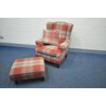 A NEXT UPHOLSTERED WINGED ARMCHAIR with matching footstool both with a red/beige tartan upholstery