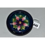 A MOORCROFT POTTERY SMALL CIRCULAR BOWL WITH SCROLL OVER RIM, decorated with a pink / purple