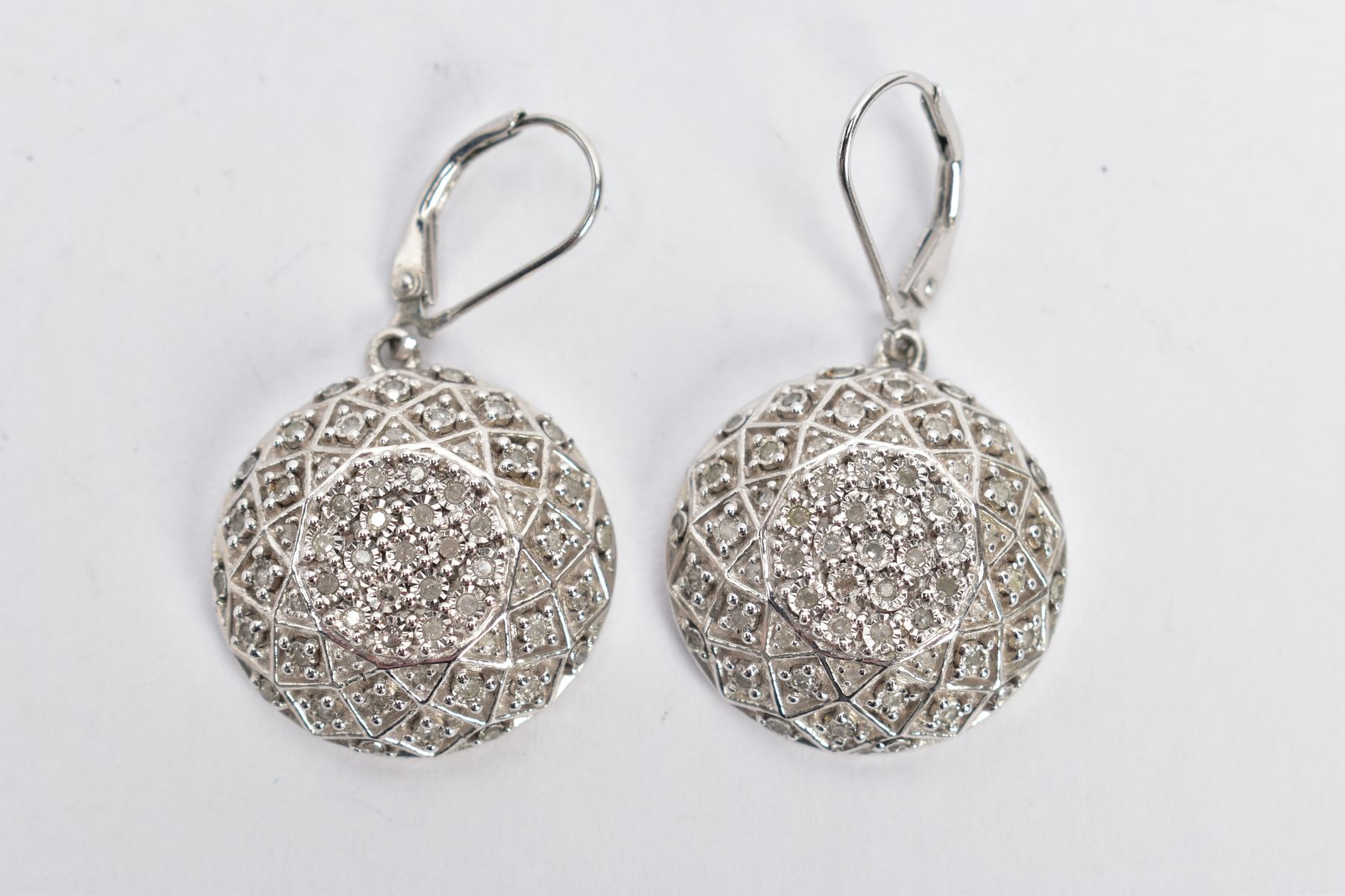 A PAIR OF WHITE METAL DIAMOND ENCRUSTED DROP EARRINGS, each of a circular domed design encrusted