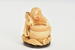 A CHINESE IVORY NETSUKE, a small carved ivory netsuke depicting a person at a cooking pot, floral