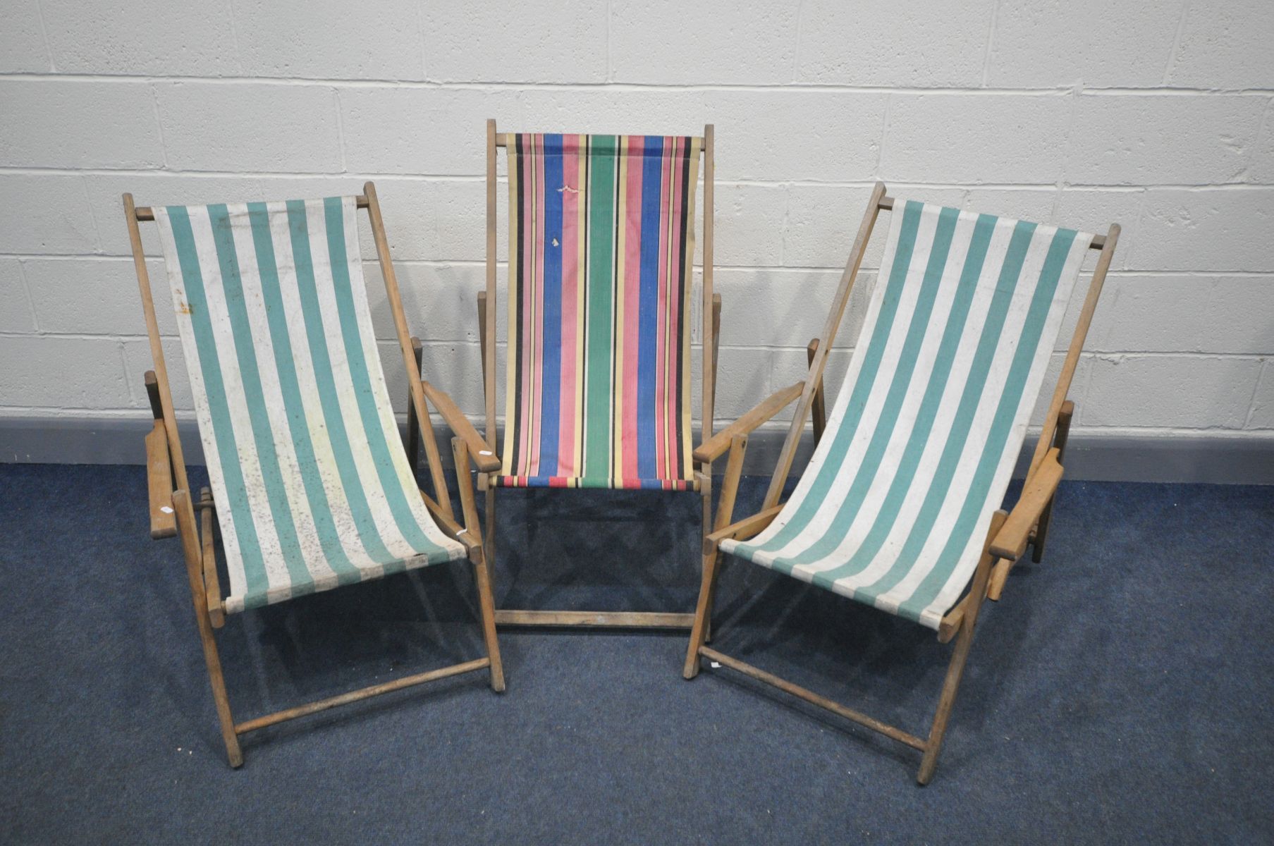TWO VINTAGE FOLDING DECK CHAIRS with armrests, and green stripped fabric, and another folding deck