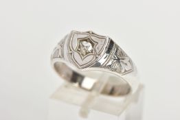 A DIAMOND SIGNET RING, the shield shape panel set with an old cut diamond, tapered shoulders and