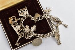 A SILVER CHARM BRACELET, curb link bracelet fitted with fifteen charms in forms such as a street