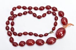 A CHERRY AMBER BAKELITE BEAD NECKLACE, graduated oval beads, largest measuring 25.4mm x 19.4mm,