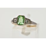 A GREEN PASTE RING, centring on an emerald cut green paste, flanked with two colourless circular cut