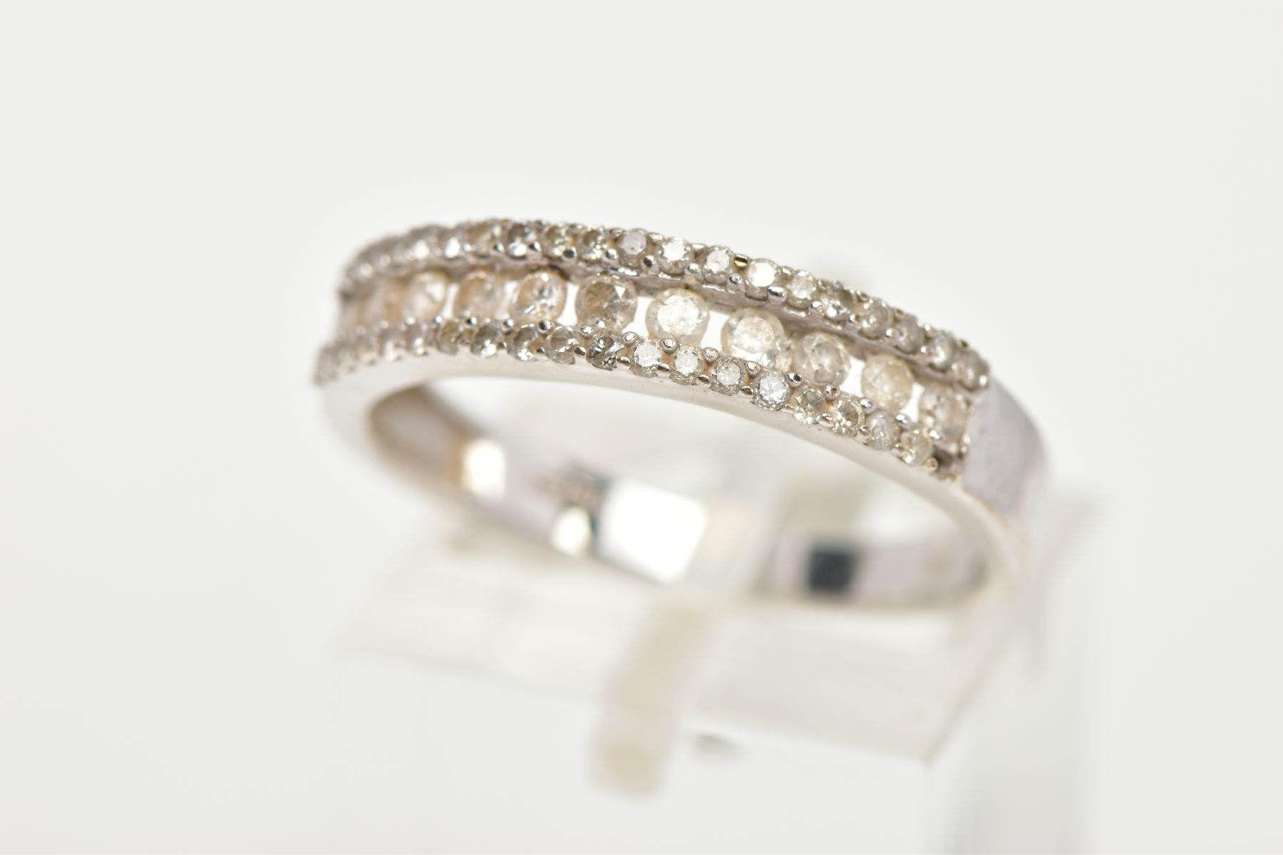 A 9CT WHITE GOLD DIAMOND HALF ETERNITY RING, designed with a central row of round brilliant cut