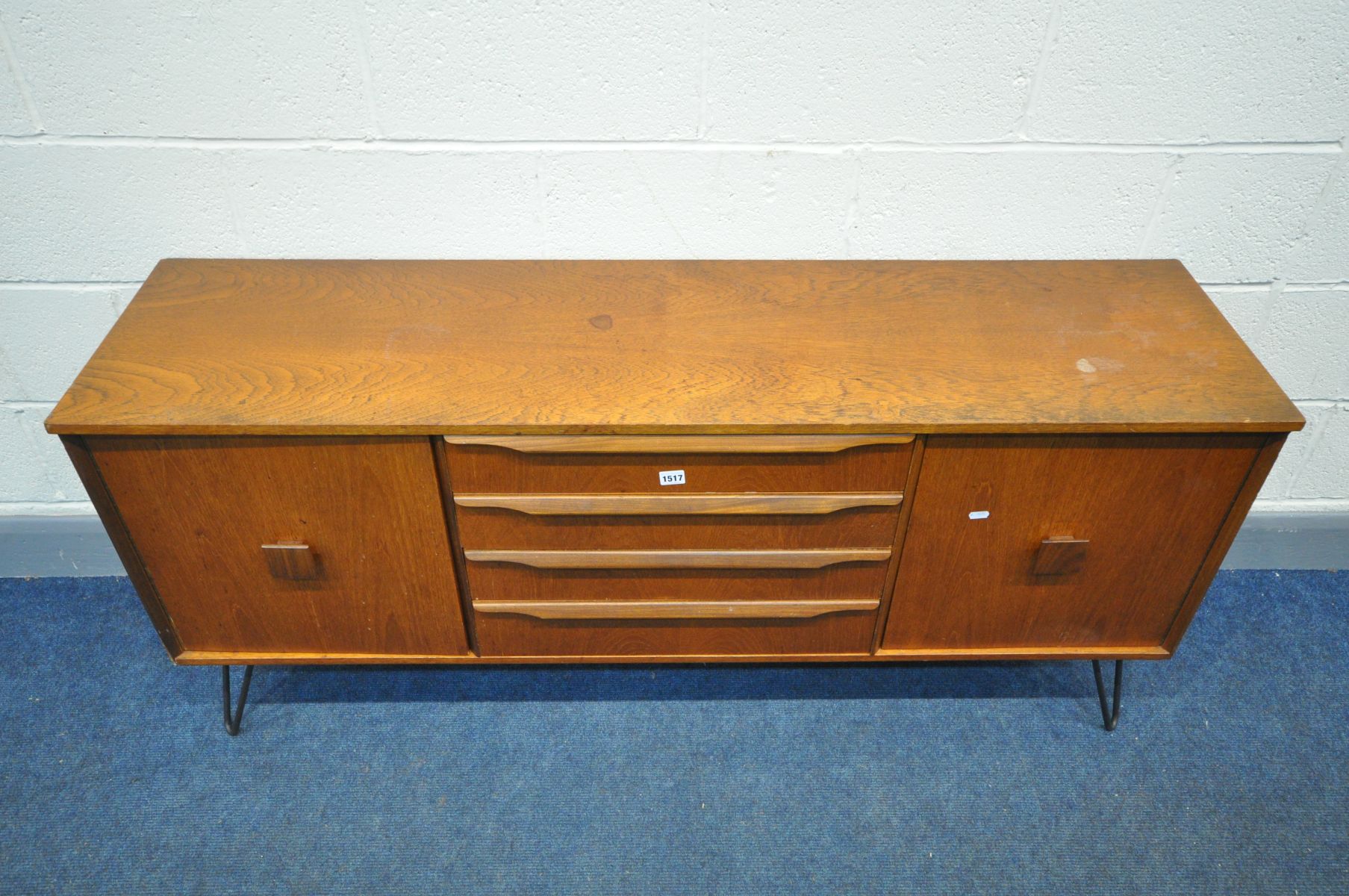 A MID CENTURY TEAK SIDEBOARD with two cupboard doors flanking four drawers on later metal hairpin - Image 2 of 3