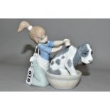 A LLADRO 5445 BASHFUL BATHER SCULPTURE OF A GIRL WASHING A DOG, designed by Juan Huerta in 1988,