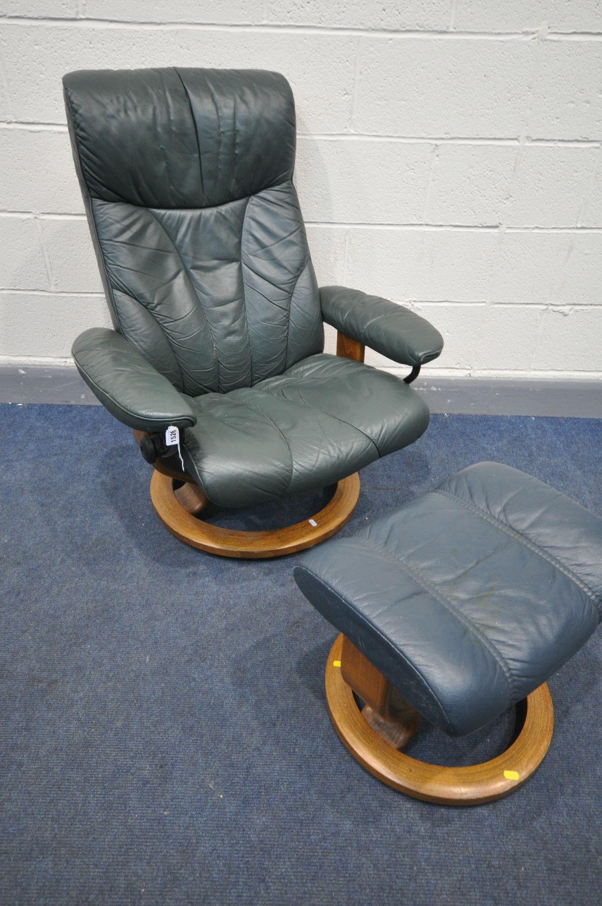 A GREEN LEATHER EKORNES STRESSLESS RECLINING SWIVEL ARMCHAIR, and a matching blue leather stool (2)
