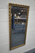 A GILT BEVELLED EDGE MIRROR, 45cm x 99cm (condition:-losses)