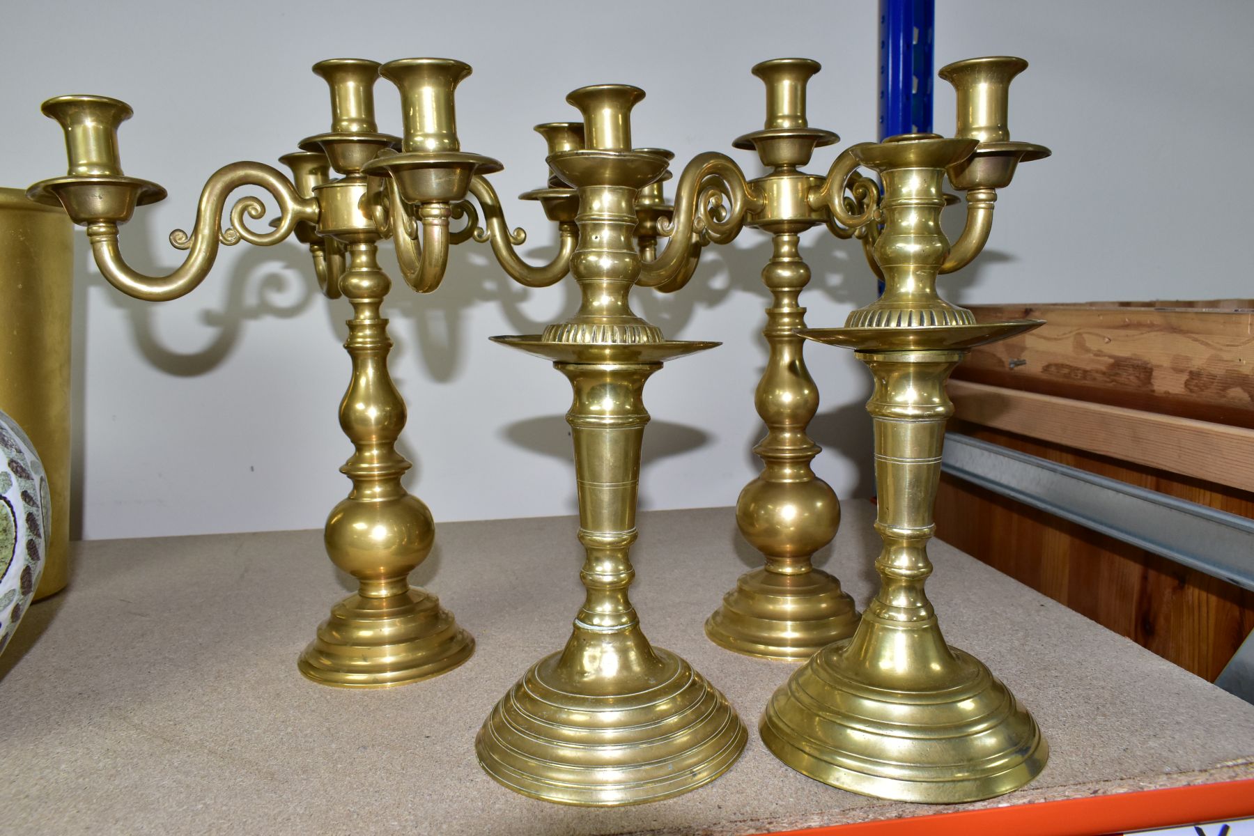 A PAIR OF MODERN BRASS FIVE BRANCH CANDELABRA AND A MATCHED PAIR OF BRASS CANDLESTICKS, the