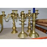 A PAIR OF MODERN BRASS FIVE BRANCH CANDELABRA AND A MATCHED PAIR OF BRASS CANDLESTICKS, the