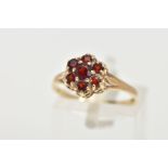 A 9CT GOLD GARNET CLUSTER RING, flower cluster set with seven circular cut garnets, prong set,