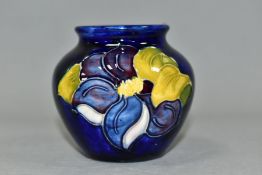 A SMALL MOORCROFT POTTERY BALUSTER VASE, decorated with tube lined blue Clematis pattern on a dark