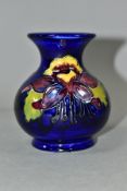 A SMALL MOORCROFT POTTERY COLUMBINE VASE, of globular form, with tubelined purple, yellow and