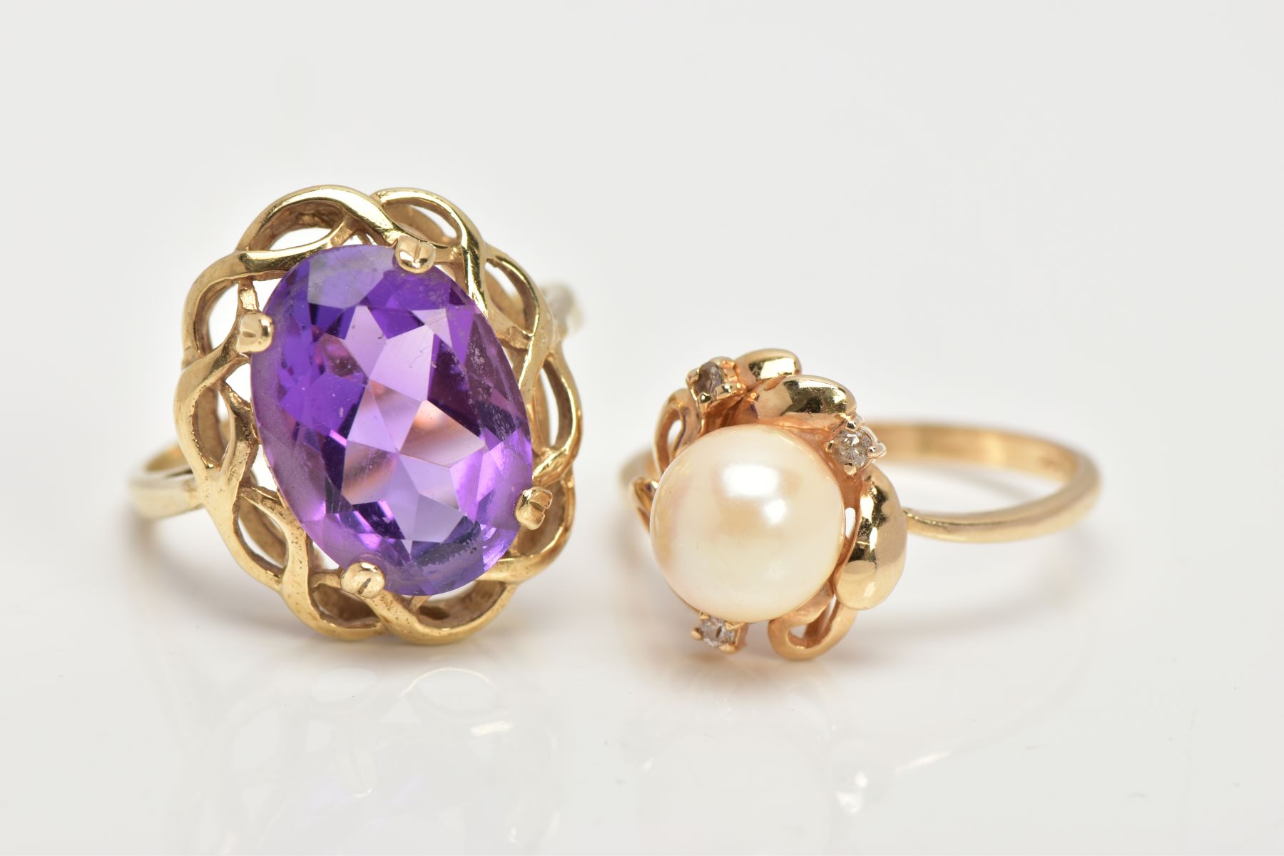 A 9CT GOLD AMETHYST RING AND A CULTURED PEARL RING, the first designed with a four claw set, oval