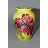 A MOORCROFT POTTERY SMALL BALUSTER VASE DECORATED WITH PINK HIBISCUS, yellow / green ground,