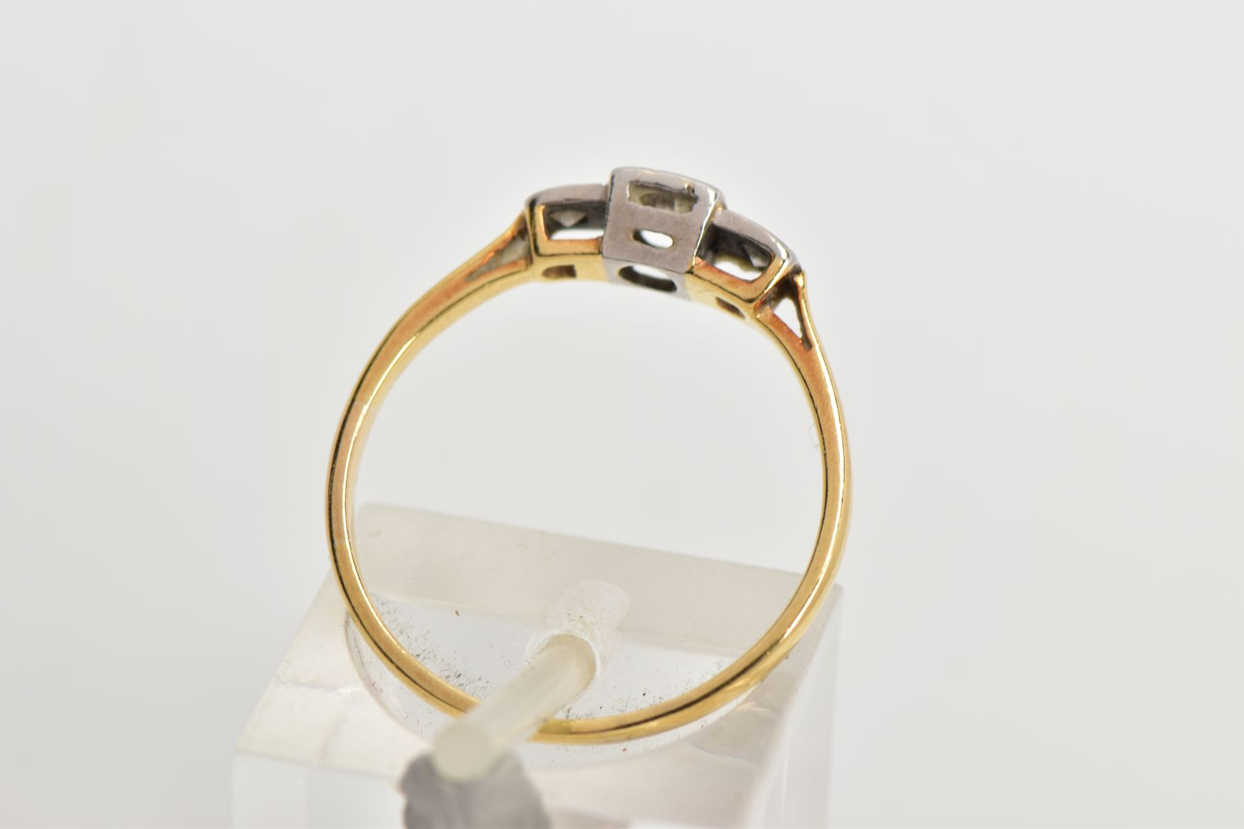 A YELLOW METAL THREE STONE DIAMOND RING, centring on a round brilliant cut diamond within a square - Image 3 of 4