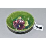 A SMALL MOORCROFT POTTERY FOOTED BOWL, decorated with tubelined purple Pansy pattern on a green/