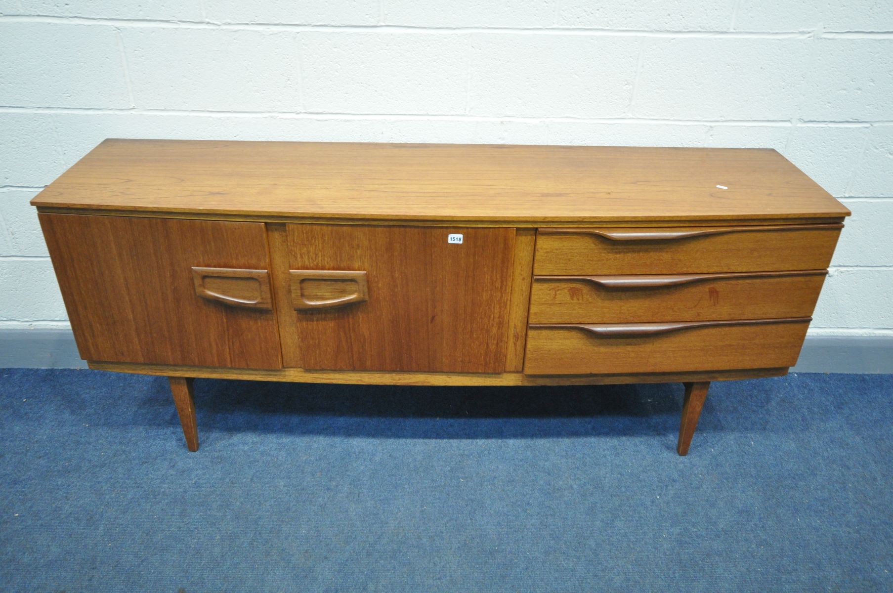A MID CENTURY BEAUTILITY TEAK SIDEBOARD, with double cupboard doors, besides three drawers,
