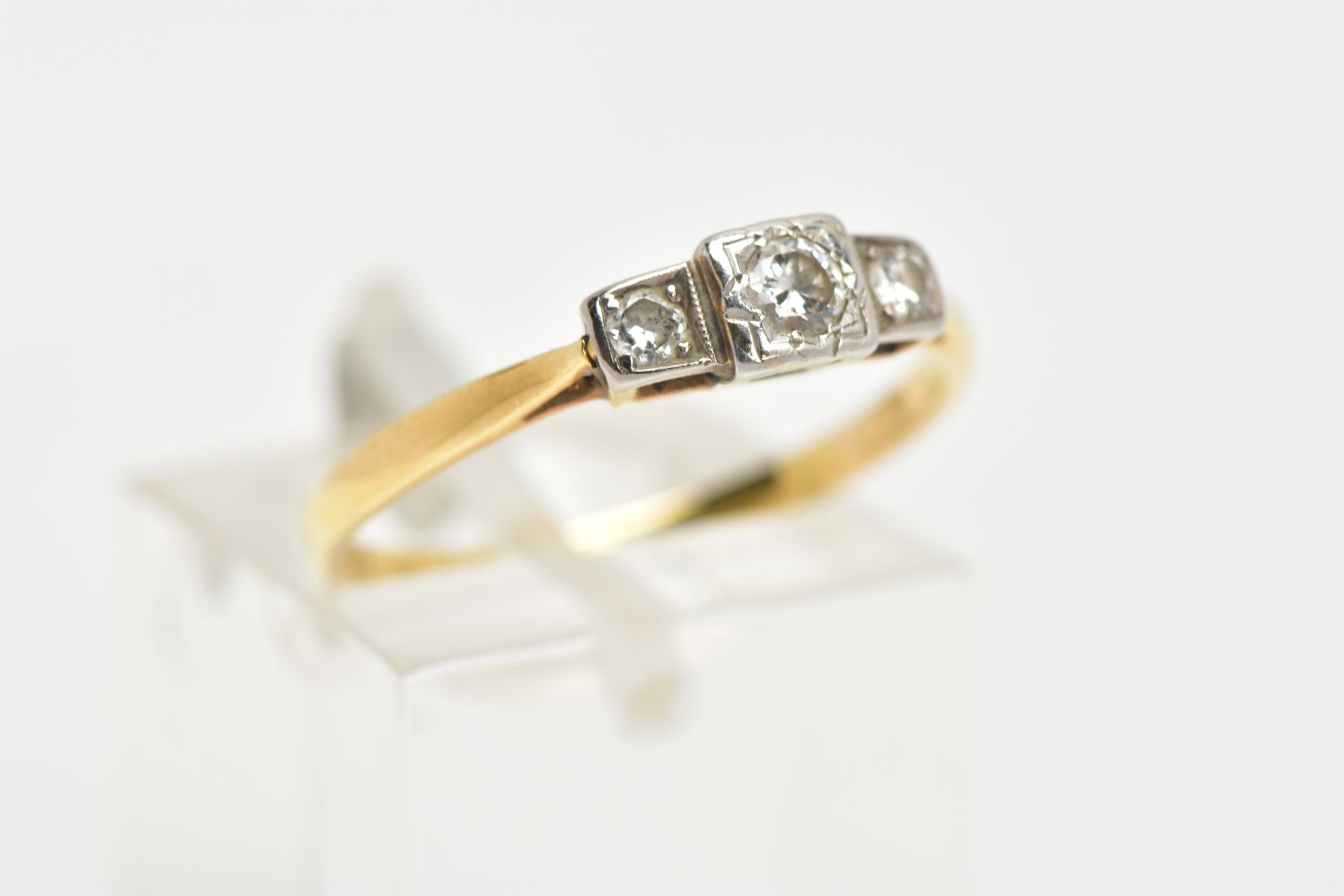 A YELLOW METAL THREE STONE DIAMOND RING, centring on a round brilliant cut diamond within a square - Image 4 of 4