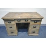 AN EARLY 20TH CENTURY OAK KNEE HOLE DESK, with two bruising slides and seven drawers with copper