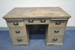 AN EARLY 20TH CENTURY OAK KNEE HOLE DESK, with two bruising slides and seven drawers with copper