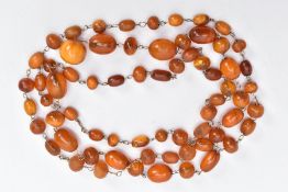 A NATURAL AMBER BEAD NECKLACE, comprising sixty seven barrel and spherical shaped beads, varying