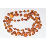 A NATURAL AMBER BEAD NECKLACE, comprising sixty seven barrel and spherical shaped beads, varying