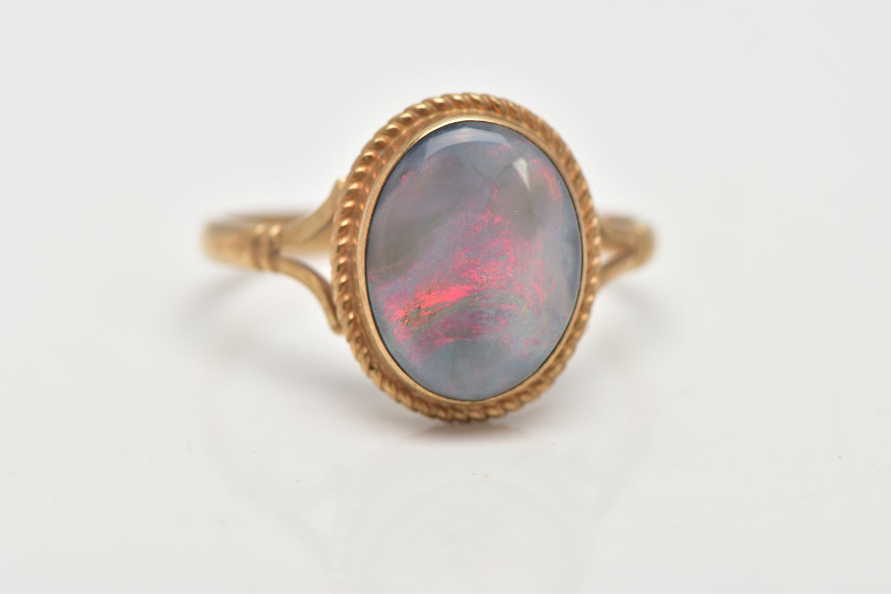 A 9CT GOLD OPAL RING, of an oval design, set with an opal cabochon, displaying blue and red play - Image 4 of 4
