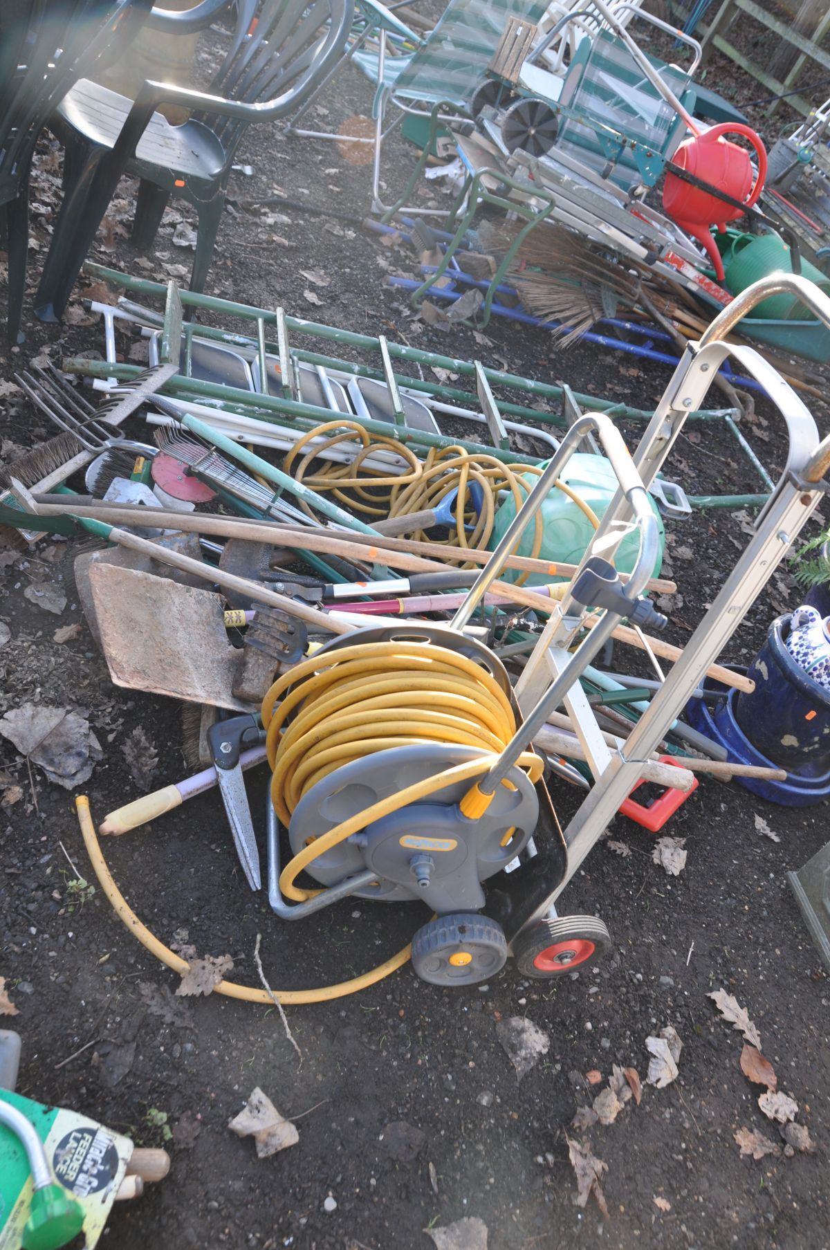 TWO GARDEN HOSE REELS, TWO STEEL STEP LADDERS and a quantity of garden tools including a builders