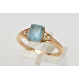 A YELLOW METAL GEM SET RING, designed with a central rectangular cut aquamarine in a four claw