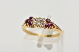 A DIAMOND AND RUBY RING, six old cut diamonds prong set in yellow metal, accented with three