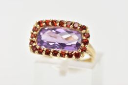 AN AMETHYST AND GARNET DRESS RING, a fancy cut amethyst set with a halo of circular cut garnet