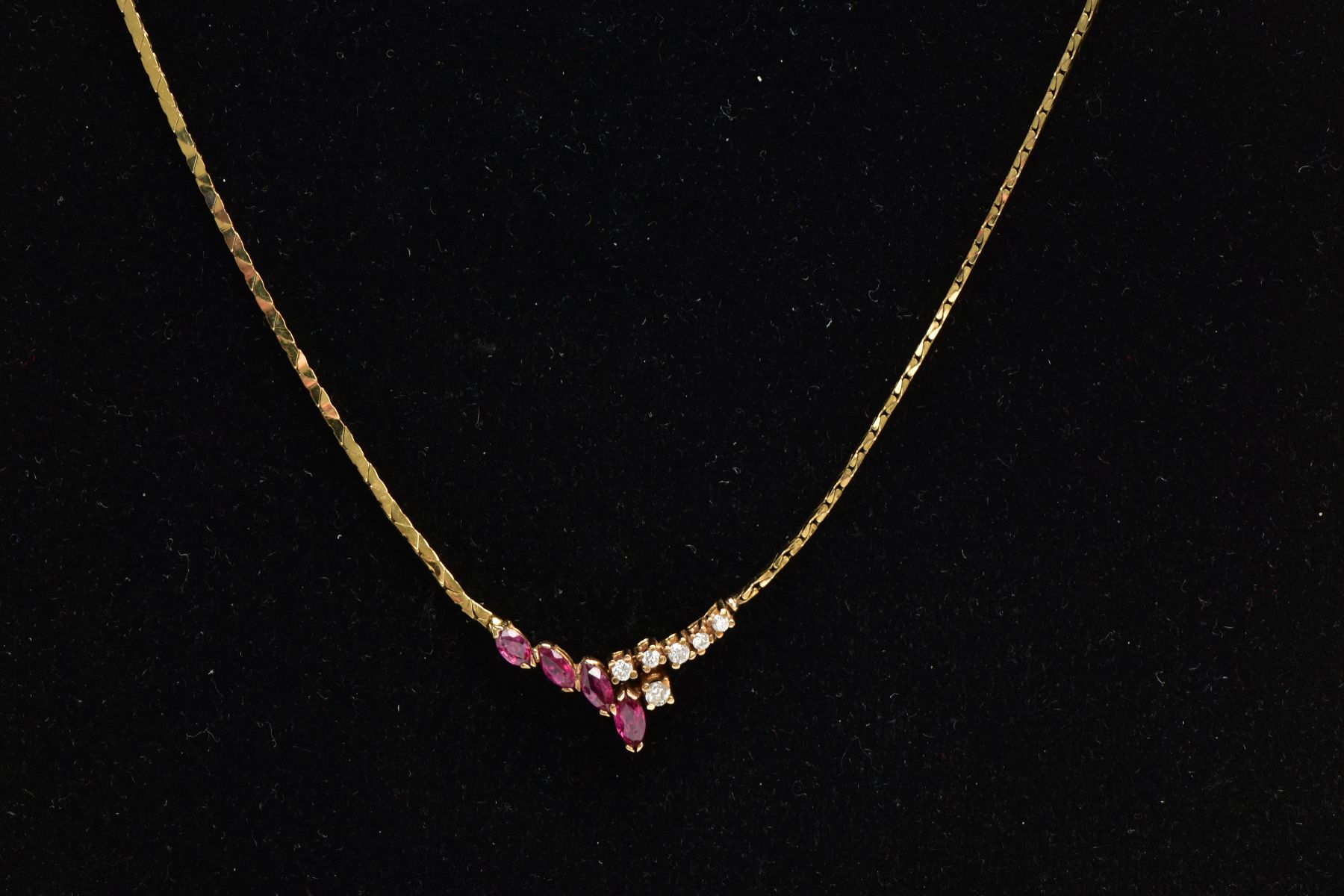 A RUBY AND DIAMOND COLLAR NECKLACE, a yellow metal flat link chain leading onto four graduating