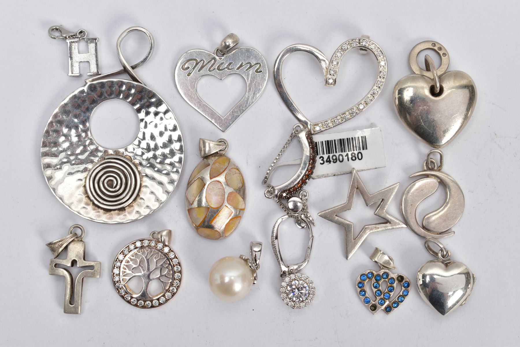 AN ASSORTMENT OF WHITE METAL JEWELLERY, to include thirteen pendants, a ring with chain fastening,